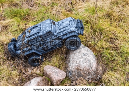 View of radio-controlled toy off-road vehicle in camouflage colors, navigating rough terrain. Sweden.