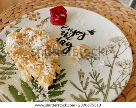 Shell-shaped macaroni with cheese and minced chicken, baked in a creamy sauce. The dish is decorated with a rose of roasted red bell peppers.