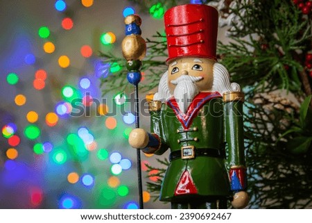 Hazelnut crusher lead soldier on a background of Christmas lights Royalty-Free Stock Photo #2390692467