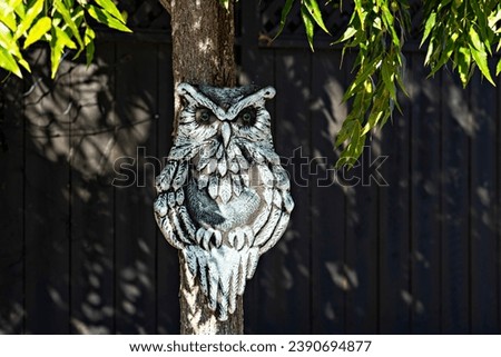 Silver Owl with Green Eyes Hangs from a Tree in the Neighborhood