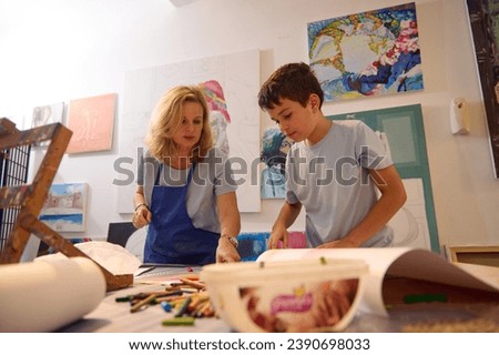 Authentic portrait of an art school student boy and female artist painter teacher during painting lesson. Individual art-class concept. Drawing. Painting. Fine and visual art class concept