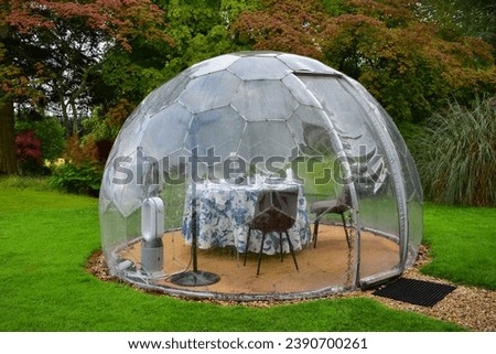 Heated transparent dome or pod for outdoor dining, table set for 2 persons Royalty-Free Stock Photo #2390700261