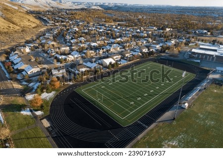aerial view of a football field with a city in the background