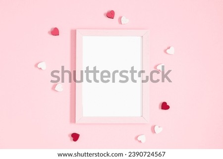 Valentine's Day composition. Photo frame and hearts on pastel pink background. Wedding. Birthday. Happy woman's day. Mothers Day. Flat lay, top view, copy space