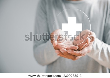 Depicts hand holding plus icon for medical care. Health insurance health concept with access to welfare health and room for text. Emphasizes value enhancement in healthcare.