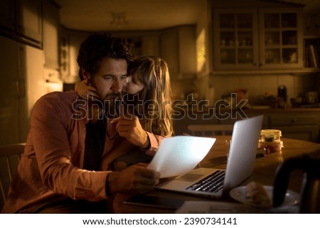 Little daughter comforting father during financial crisis at home Royalty-Free Stock Photo #2390734141