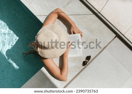 woman relaxing in a luxury spa pool wearing a hat and reading a book