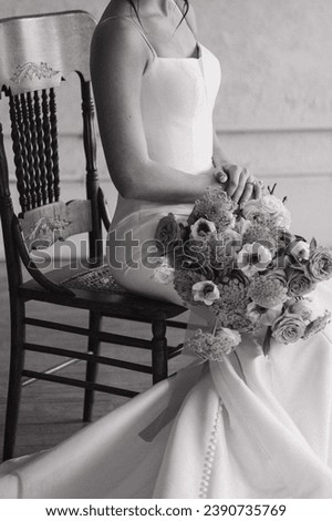 editorial black and white photo of an elegant modern bride sitting in a chair holding her bouquet
