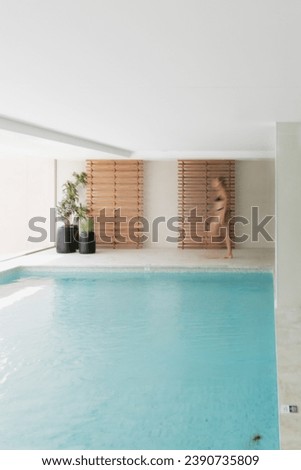 Motion blur effect of a woman walking in a wellness center spa with swimming pool at a luxury hotel