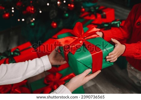 Gift box in the hands of mother and son, Christmas mood.