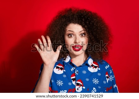 Photo portrait of pretty young girl waving hand excited hello dressed stylish blue x-mas print outfit isolated on red color background