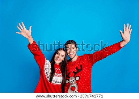 Photo portrait of pretty young lovers waving hands excited hello wear x-mas ornament red sweaters isolated on blue color background