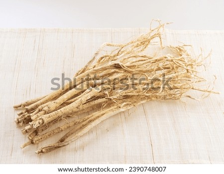 Close up of stacked dried medicinal herbs of milk vetch roots on cloth floor, South Korea
 Royalty-Free Stock Photo #2390748007