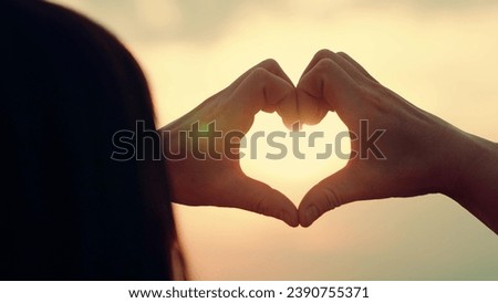 Girl molded love heart from her palms. Light of summer spring sun is in my hands. Travel, relax, nature. Heart symbol, love, healthy. Happy girl making heart shape with fingers. Healthy heart concept