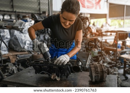 Female auto mechanic are repair and maintenance auto engine is problems. Engineer inspecting motor part problems. Woman empowerment working in automotive maintenance service industry.