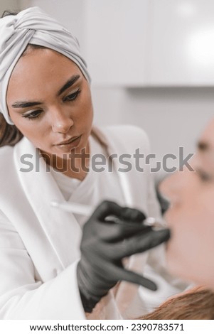Vertical portrait with focus on a concentrated beauty doctor working in a beauty treatment clinic Royalty-Free Stock Photo #2390783571