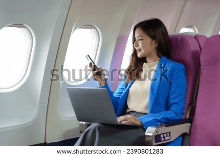 Asian businesswoman uses laptop computer in airplane business travel Online communication and media sharing technology from laptop during flight on airplane working lifestyle concept.