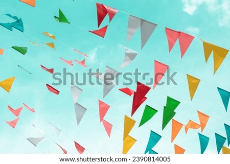 Fair flag bunting colorful background hanging on blue sky for fun fiesta party event, summer holiday farm feast celebration, carnival festival event, park or street festa design decoration