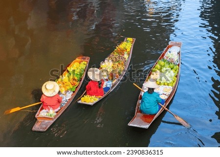 Farmers row boats at the floating market selling local Thai food. Organic vegetables and fruits and Thai tourism culture concept The famous Damnoen Saduak Floating Market of Ratchaburi Province. Royalty-Free Stock Photo #2390836315