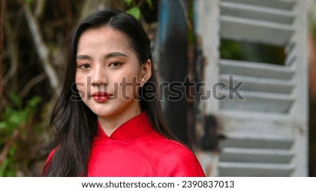 A young girl is wearing Vietnamese traditional ao dai. Video for tourism, culture, tradition, and the beauty of Asian people Royalty-Free Stock Photo #2390837013