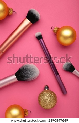 Makeup brushes decorate with christmas decor on pink background for advertising. Top view and product holiday content. Vertical photo