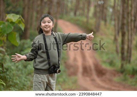 Young female traveler standing to call a car on a forest path
