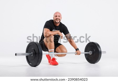 Portrait isolated cutout full body studio shot strong Caucasian male fitness athlete sporstman trainer model in casual sport workout outfit posing lifting barbell training on white background. Royalty-Free Stock Photo #2390854023