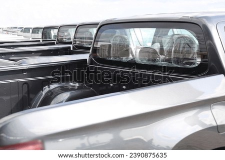 new grey SUV PICKUP vehicle, back view. Photography of a many, a lot modern pickup. made in Japan. parking in long perspective. back, rear view.  Royalty-Free Stock Photo #2390875635