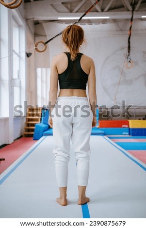 Parkour Woman standing on the back of the Safety Mat. Vertical photo. 