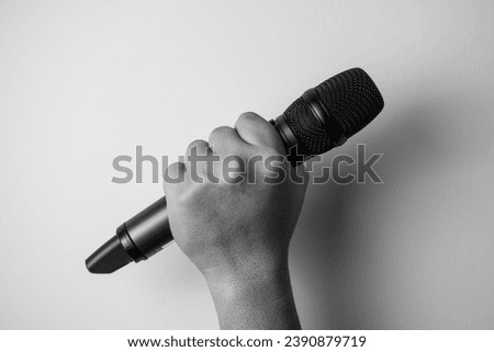hands holding wireless microphone on white background.