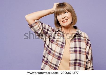 Elderly mistaken sad gray-haired woman 50s years old wear beige t-shirt shirt casual clothes look aside on area hold scratch head isolated on plain pastel light purple background. Lifestyle concept