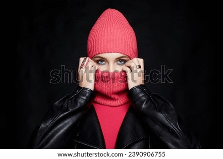 beautiful girl in balaclava and leather coat. Trendy Mask on pretty woman. New Hat style Royalty-Free Stock Photo #2390906755