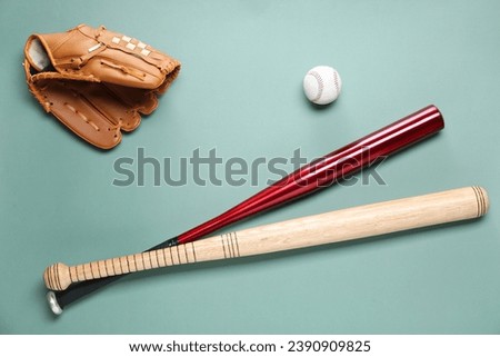 Baseball glove, bats and ball on pale green background, flat lay