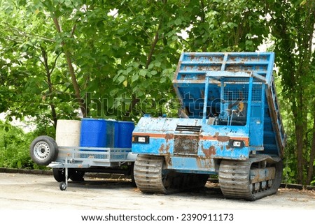 Abandoned blue dump truck and trailer carrying many oil tanks at old storage place in forest natural and sunlight background for concept of Industry and transportation.
