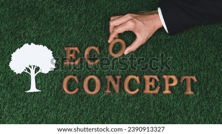 Hand arrange wooden alphabet in ecological awareness campaign with ECO icon design on biophilia green grass background to promote environmental protection for greener and sustainable future. Gyre