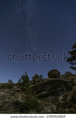 Winter Milky Way and Andromeda galaxy over rocky pure landscape illuminated by moonlight, Vale do Rossim, Serra da Estrela, Portugal