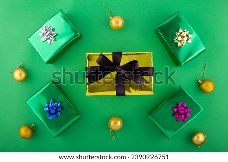 Don't delay, begin your holiday shopping adventure now. Top view shot of presents, holiday decor, sparkles on green background with marketing space