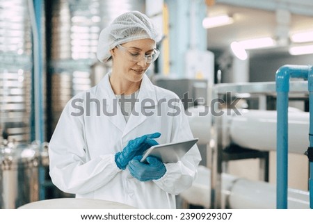 Happy senior science staff women worker work control quality of water in drinking water plant using tablet to record jobs. Royalty-Free Stock Photo #2390929307