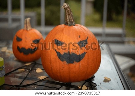 Scary pumpkin. Celebration of the holiday. Black eyes painted on a pumpkin. Day of Evil Spirits.