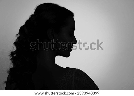 Silhouette of one woman on light grey background, profile portrait. Space for text