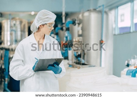 hygiene staff worker in foods and drinks clean factory. working women in water plant industry quality control check. Royalty-Free Stock Photo #2390948615