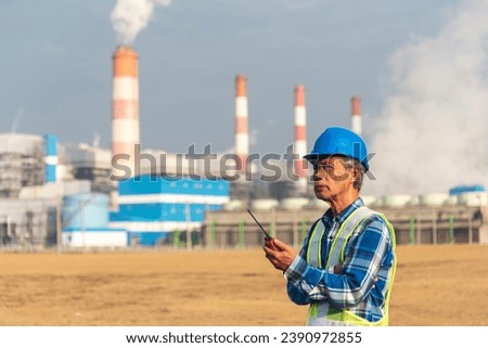 Senior Electrician engineer man hand holding red Walkie talkie communicate wear White hardhat at Power stations manufacturing electrical plant. Technician worker blue hard hat helmet Engineer industry Royalty-Free Stock Photo #2390972855