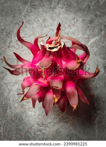the stunning contrast of a vibrant red dragon fruit set against the timeless elegance of a marble background