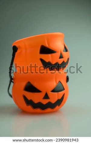 Scary Halloween plastic pumpkin. Child collecting candy Jack o'lantern basket , trick or treat, seasonal celebration.