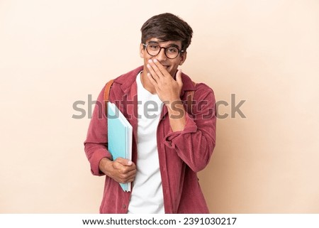 Young student caucasian man isolated on ocher background happy and smiling covering mouth with hand Royalty-Free Stock Photo #2391030217