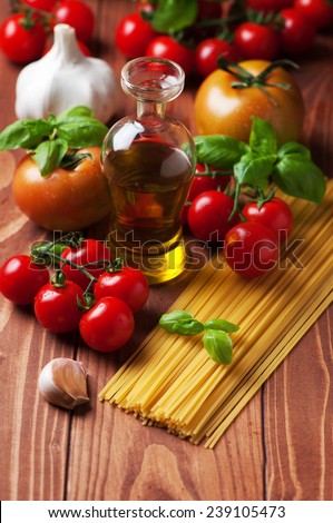 Spaghetti and tomatoes with herbs on an old wooden table