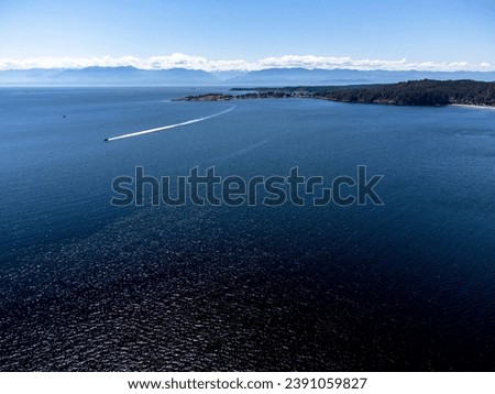 Aerial Strait of Juan De Fuca and William Head Institution near Taylor Beach Metchosin British Columbia with speed boat overlooking Washington USA at background.