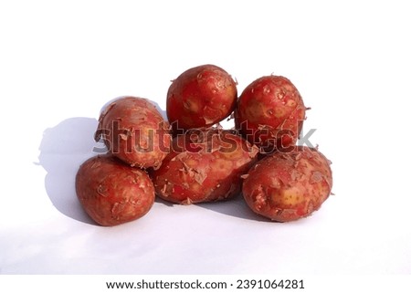 Red potatoes on a white background. Several tubers of red-skinned potatoes close-up, horizontal photo.