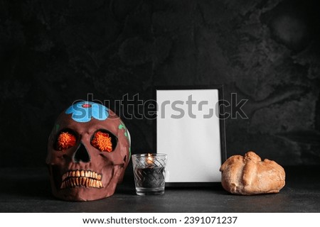 Bread of the dead with frame, candle and painted skull on black background. Celebration of Mexico's Day of the Dead (El Dia de Muertos)