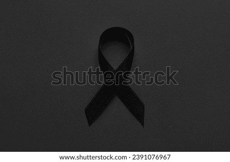 Black funeral ribbon on dark background Royalty-Free Stock Photo #2391076967